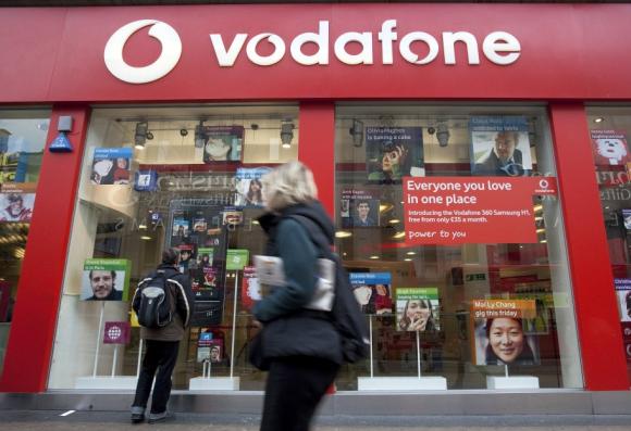 A pedestrian passes a Vodafone store on Oxford Street in central London.