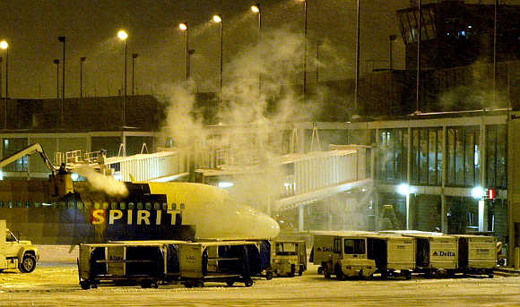 Ground crew de-ices a Spirit Airlines jet outside Terminal 3 at O'Hare International Airport in Chicago.