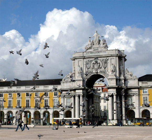 Pigeons fly around the main square of Lisbon Terreiro do Paco in Portugal.