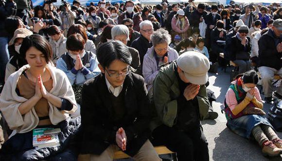 People observe a moment of silence during a rally after the magnitude 9.0 earthquake struck off Japan's coast.