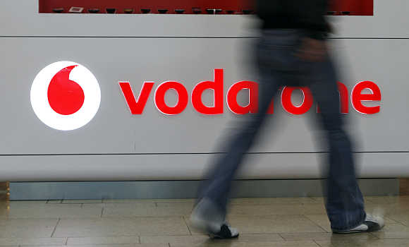 A customer walks past the Vodafone logo in a shopping mall in Prague, the Czech Republic.