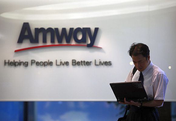 A man looks at his laptop outside Amway's sales showroom.
