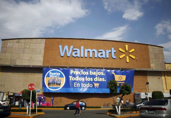 People walk past a Wal-Mart store with a banner reading ''Low prices, every day, in everything'' in Mexico City.