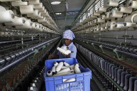 A worker handles the production of yarn on a yarn-spinning equipment at a factory.