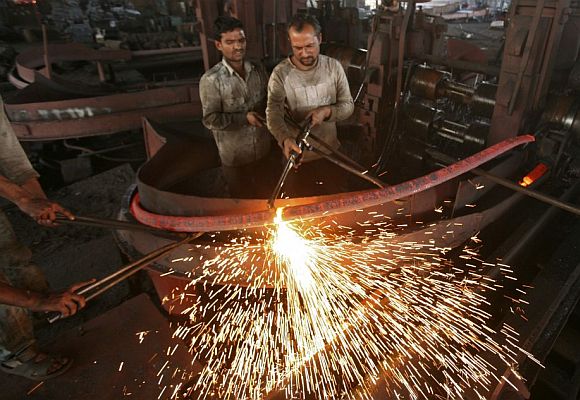 Labourers work inside an iron factory.