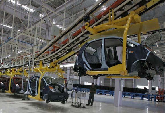 An employee stands inside the Tata Nano plant at Sanand.