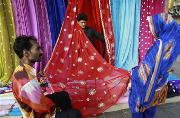 Men display fabric to a woman.
