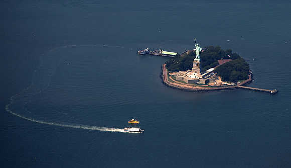 A passenger ferry leaves the The Statue of Liberty and Liberty Island seen from this aerial view over New York Harbor.