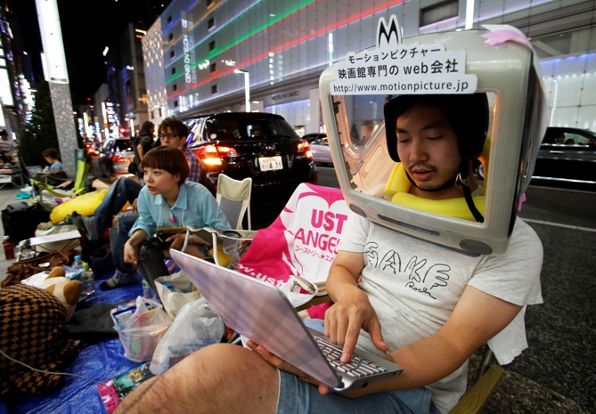 A man wearing an iMac on his head waits for the release of Apple's new iPhone 5S, near the Apple Store at Tokyo's Ginza shopping district.