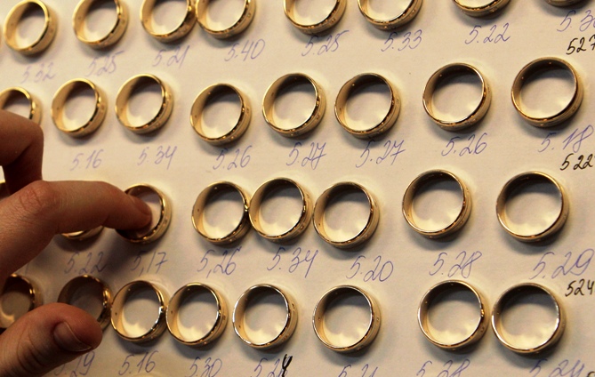 A worker sorts gold rings.