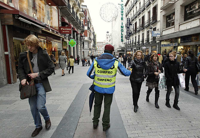 A pawn shop employee distributes leaflets in downtown Madrid, Spain.