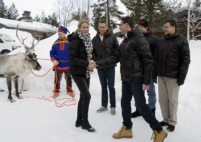 Prime Minister of Denmark Helle Thorning-Schmidt, left, greets her Finnish counterpart Jyrki Katainen, right, in Saariselka, Finland.