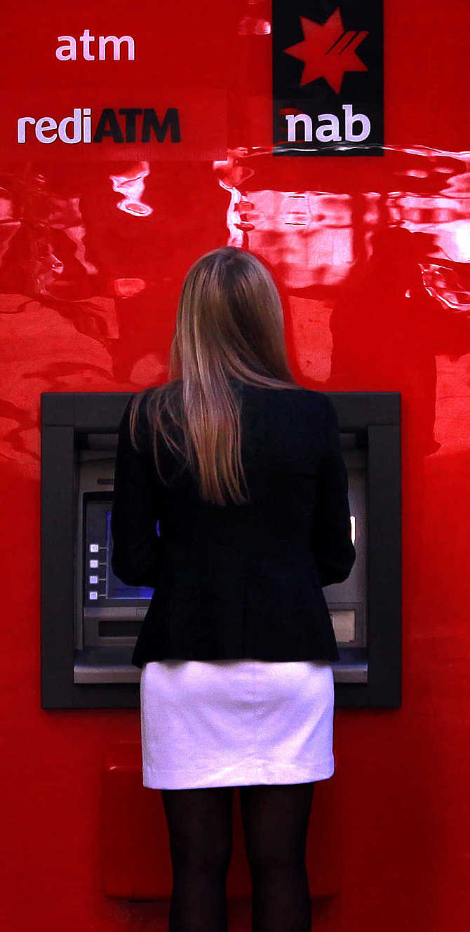 A woman uses a National Australia Bank's ATM in central Sydney, Australia.