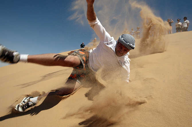 A tourist enjoys sand surfing near the Dakhla oasis in Egypt's Western Desert, some 900km southwest from Cairo.