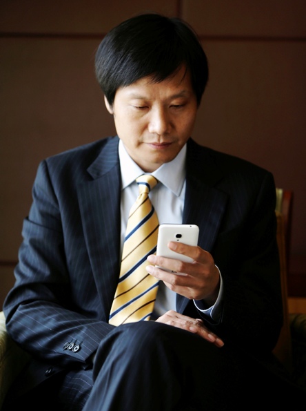 Lei Jun, founder and CEO of China's mobile company Xiaomi, checks his Xiaomi mobile phone.