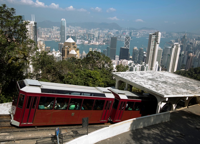 A peak tram passes a tram station on Hong Kong island.