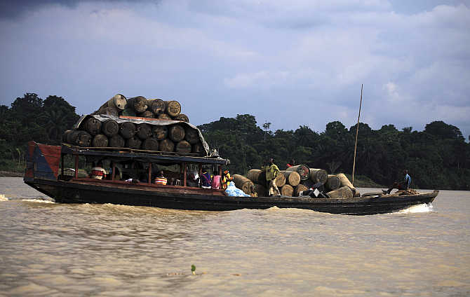 People travel on a locally built passenger boat loaded with oil containers through a creek on the River Nun in Nigeria's oil state of Bayelsa.
