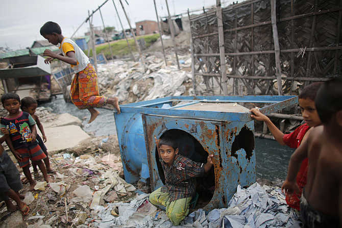 Children play around discarded items at the Hazaribagh area in Dhaka, Bangladesh.