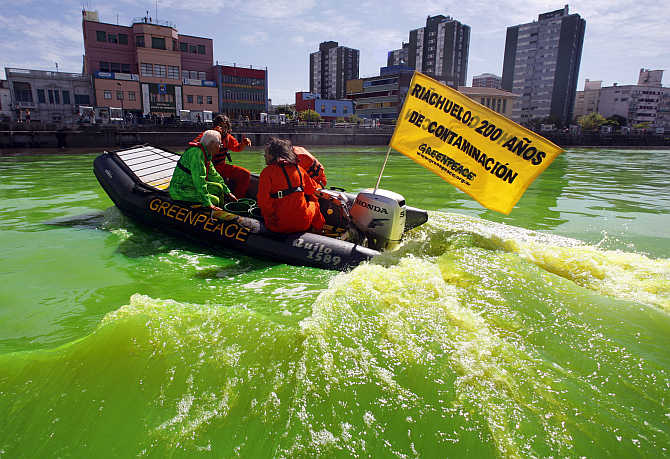 A boat with Greenpeace activists makes its way across the Matanza-Riachuelo river, Argentina's most polluted basin, after it was dyed green during a demonstration.