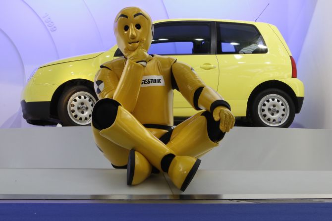 A model dressed as a crash-test dummy sits in front of a Volkswagen Lupo.