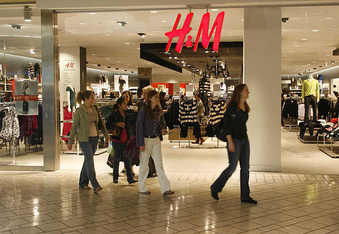 Holiday shoppers walk past fashion store H&M at The Beverly Center mall in Los Angeles, United States.