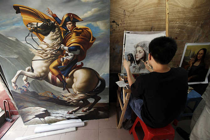A painter works on a portrait in a studio at Dafen Oil Painting Village in Shenzhen, south China's Guangdong province.