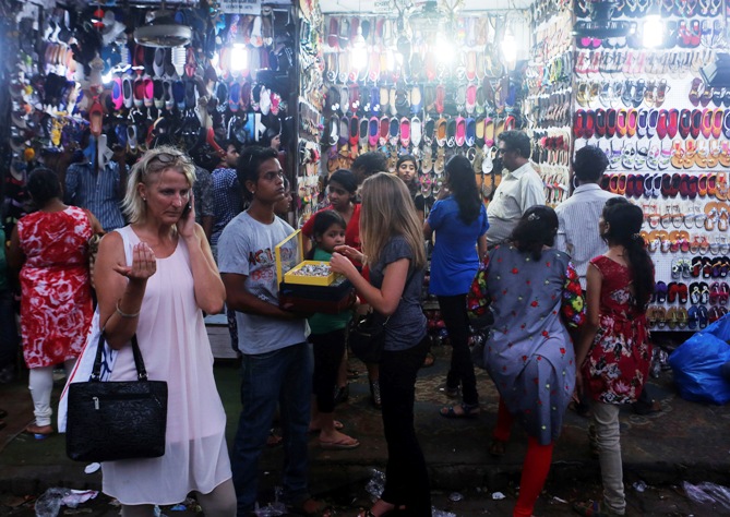 People shop from roadside stalls at a market in Mumbai. 
