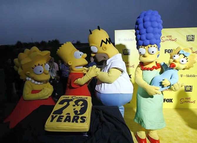 Characters (from L-R) Lisa, Bart, Homer, Marge and Maggie stand by a cake at the 20th anniversary party for the television series The Simpsons.