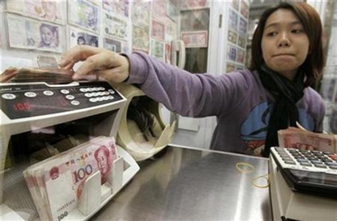 Yuan notes are counted at a currency exchange office in Hong Kong.