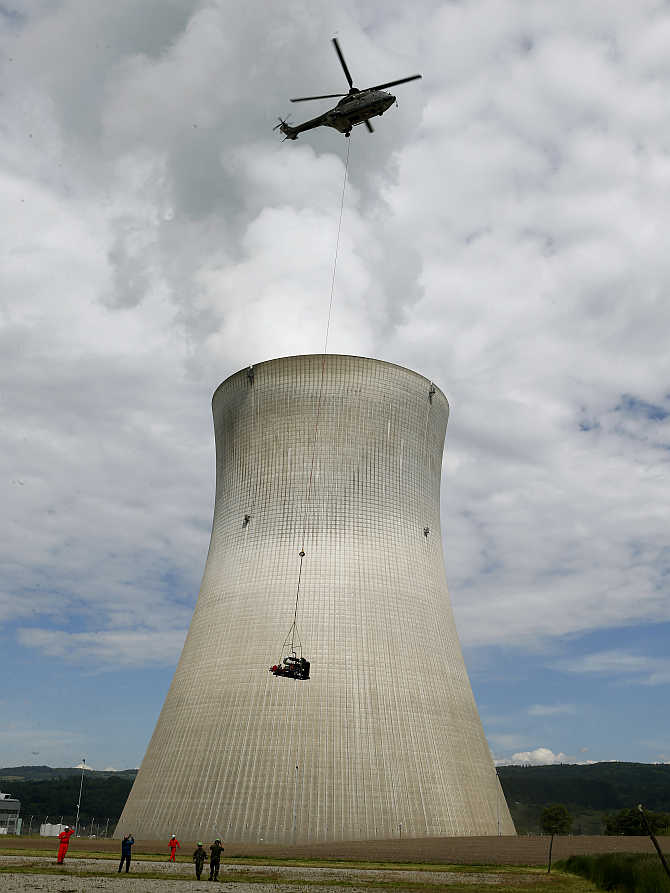 An air force helicopter transports a mobile water pump in front of the nuclear power plant near the northern Swiss town Leibstadt.