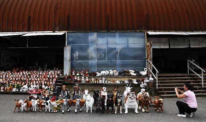 A woman takes pictures of plaster animals displayed at the road-side shop near the village of Kolesov, 90km west from Prague, the Czech Republic.