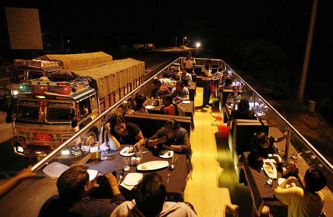 People dine on a double-decker bus which has been converted to a mobile restaurant as it travels through the streets of Ahmedabad.