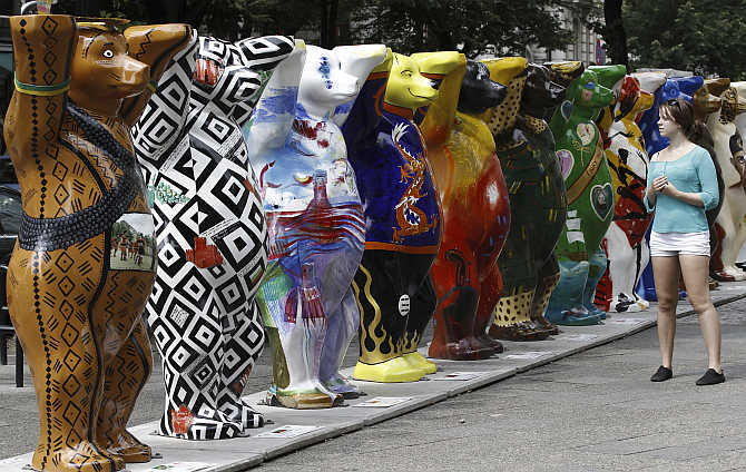 A woman looks at Buddy Bear sculptures at the Kurfuerstendamm boulevard in Berlin, Germany.