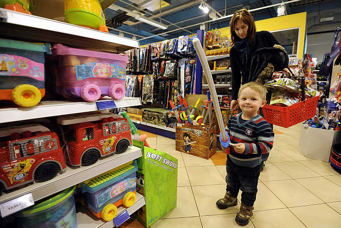 Jana Papulakova watches her two-year-old son Tobias play with a sword inside the Alltoys toy shop in Trencin, Slovakia.