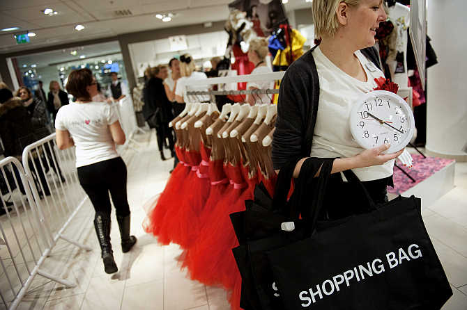 A shopper holds a clock as she walks inside Swedish fashion giant H&M's store in Stockholm, Sweden.