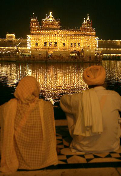Devotees pay obeisance near the holy Sikh shrine of Golden Temple on the eve of Diwali festival in Amritsar.