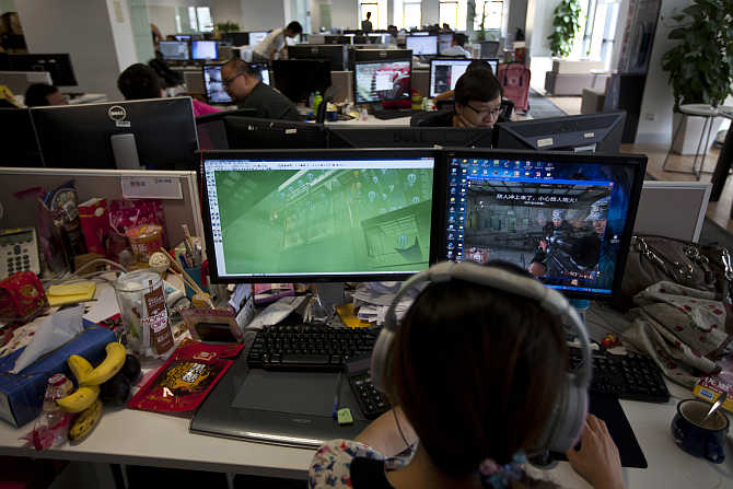 An employee watches a computer screen displaying the video game Glorious Mission Online at the game developer's office in Shanghai, China.