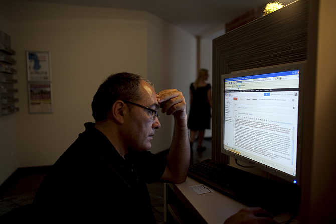 Jose Manuel Abel, 46, writes an email in an Internet cafe in Munich, Germany.