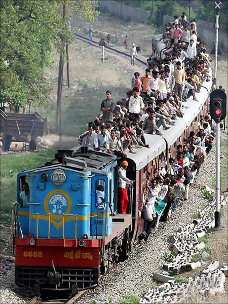 People travel on a crowded passenger train in Lucknow.