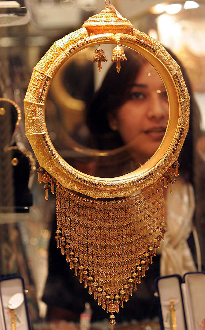 A woman looks at gold ornament in Kolkata.