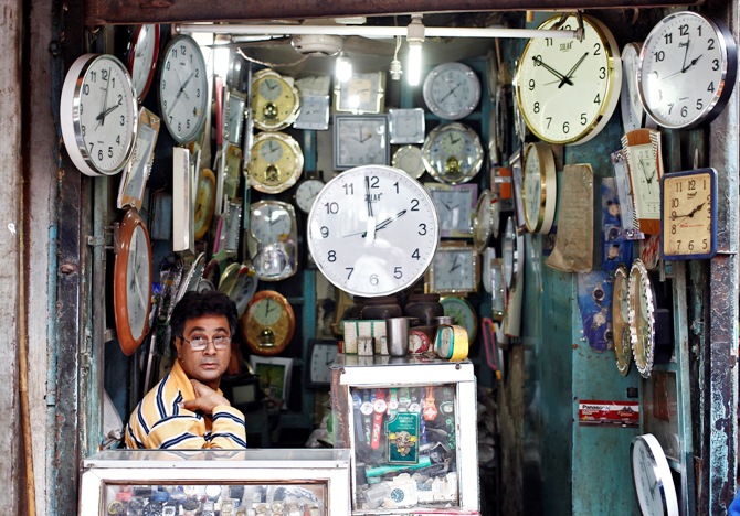 A shopkeeper waits for customers at his shop selling wall clocks in the old quarters of Delhi.