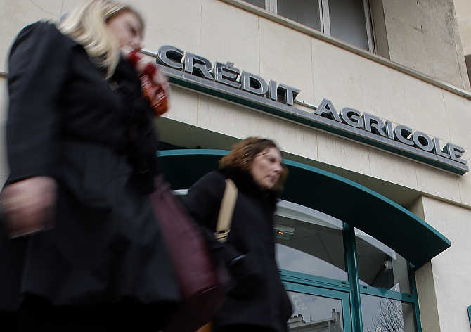 Passers-by walk in front of a branch of French bank Credit Agricole in Marseille, France.