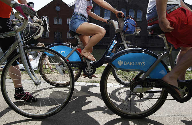 Cyclist ride bicycles sponsored by Barclays Bank at Camden Lock in London.