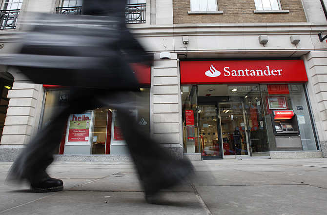 A pedestrian walks past a branch of a Santander bank in London.