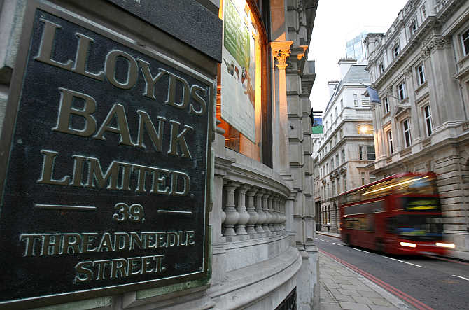 A bus passes a branch of Lloyds bank in the City of London.