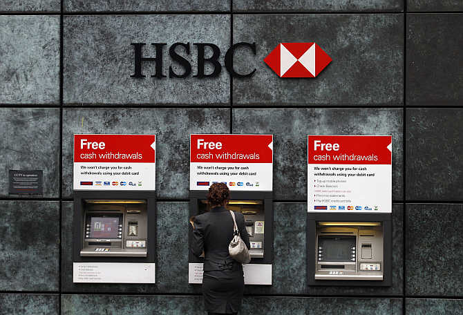 A woman uses a cash point machine at a HSBC bank in the City of London.