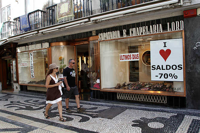 People walk past a shop in downtown Lisbon, Portugal.