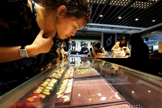 A customer looks at a few 24K gold keys left on an shelf inside a jewellery store.