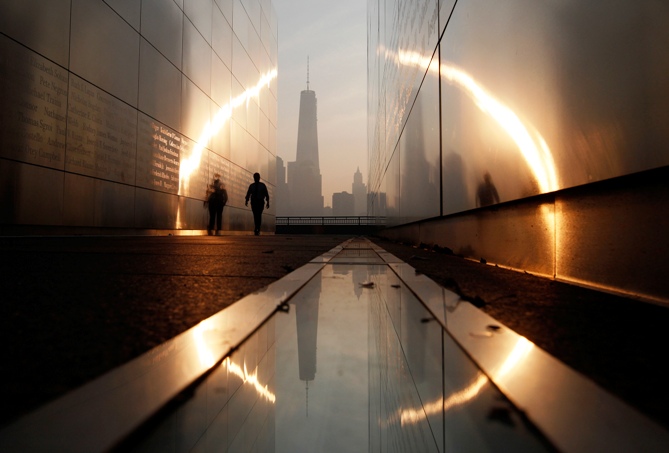 A man walks through the 9/11 Empty Sky memorial at sunrise across from New York's Lower Manhattan and One World Trade Center in Liberty State Park in Jersey City, New Jersey, September 11, 2013.