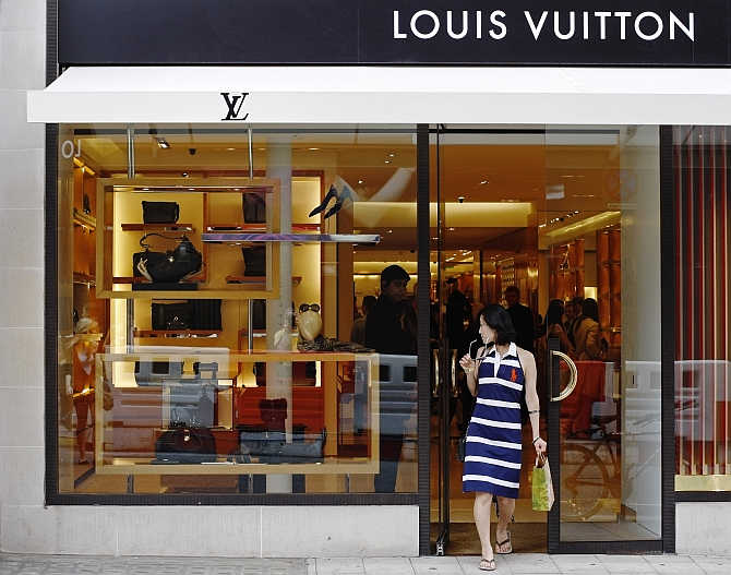 A woman exits the Louis Vuitton shop on New Bond Street in London, United Kingdom.